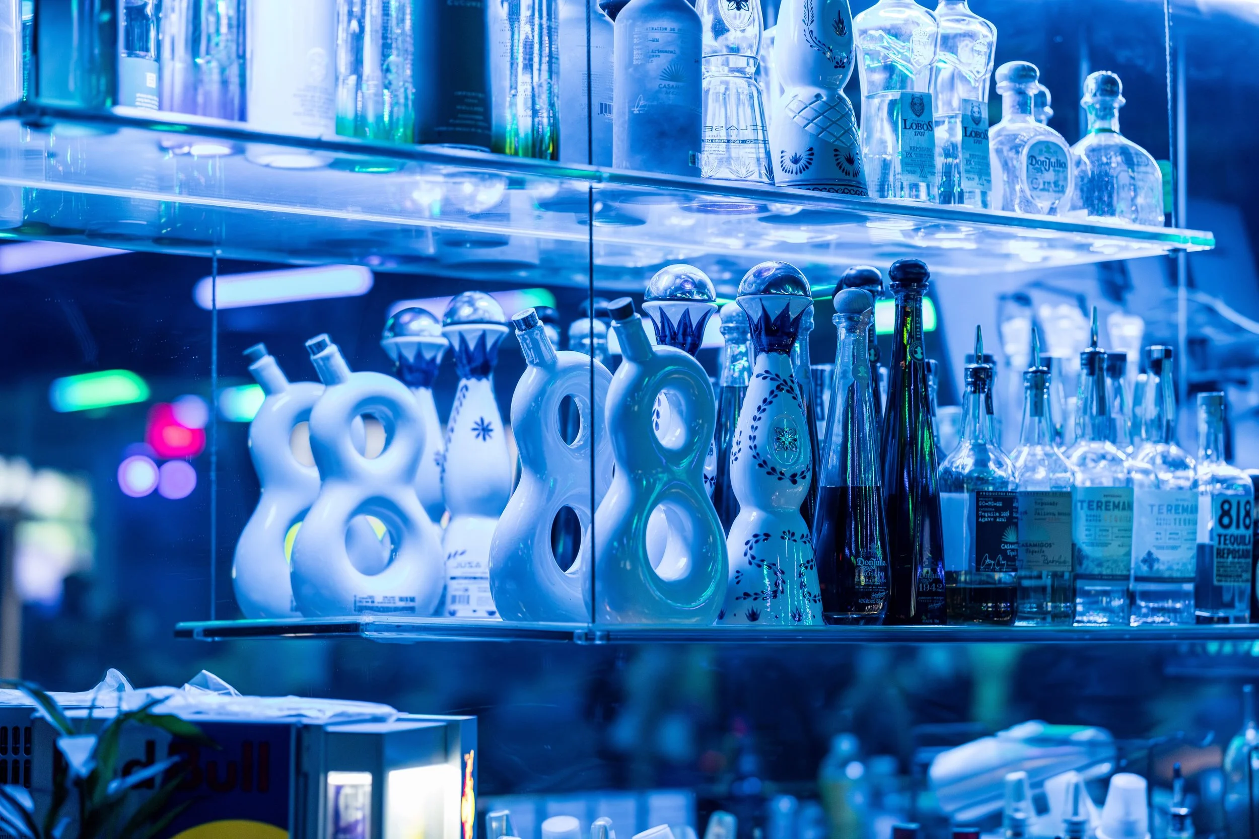 Backlit shelves of premium tequila at the Oasis bar
